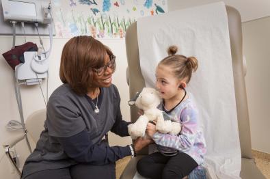 Provider and Child using a stethoscope on a stuffed animal